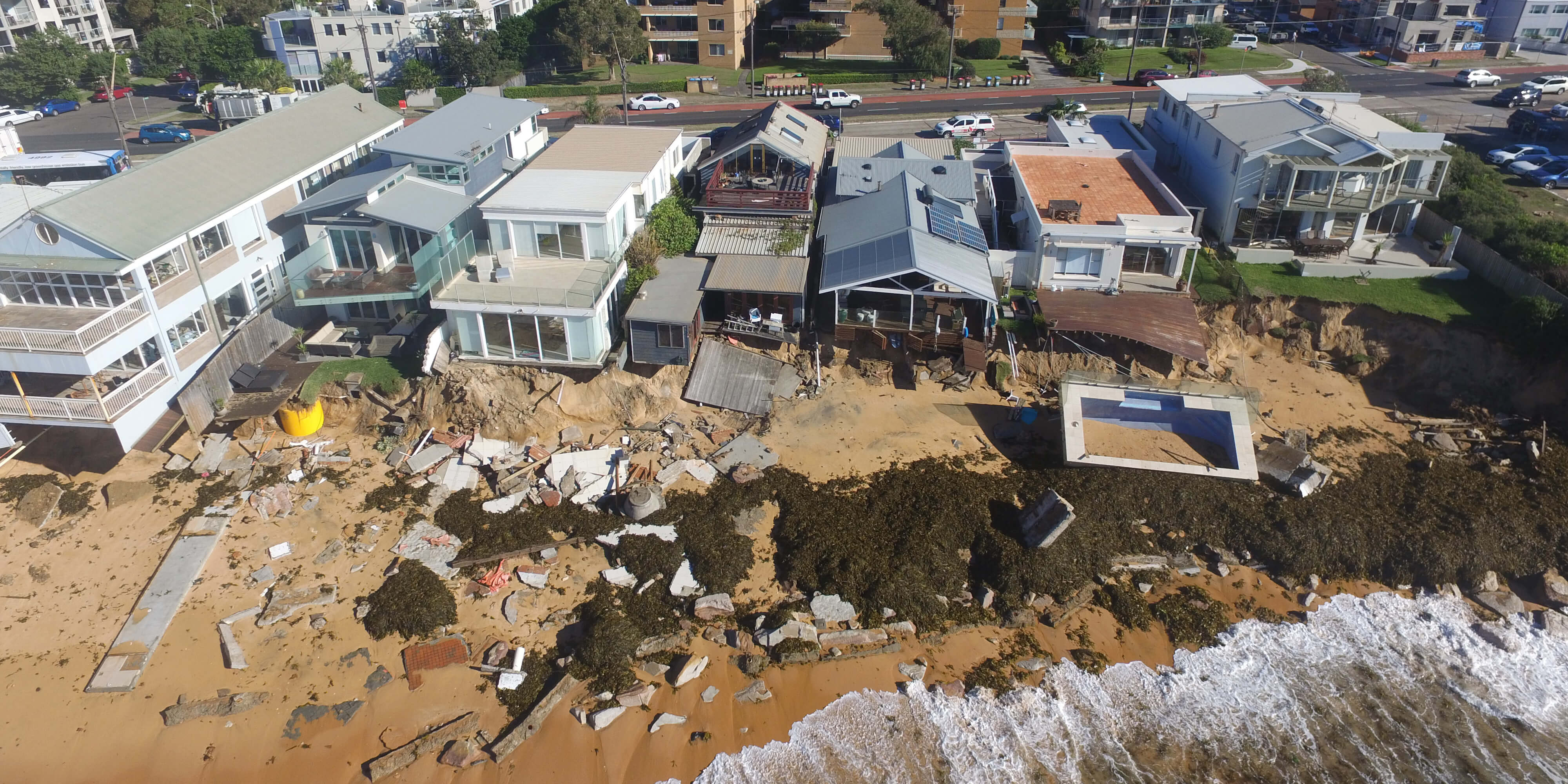 Aerial view of houses by the beach damaged after a storm.