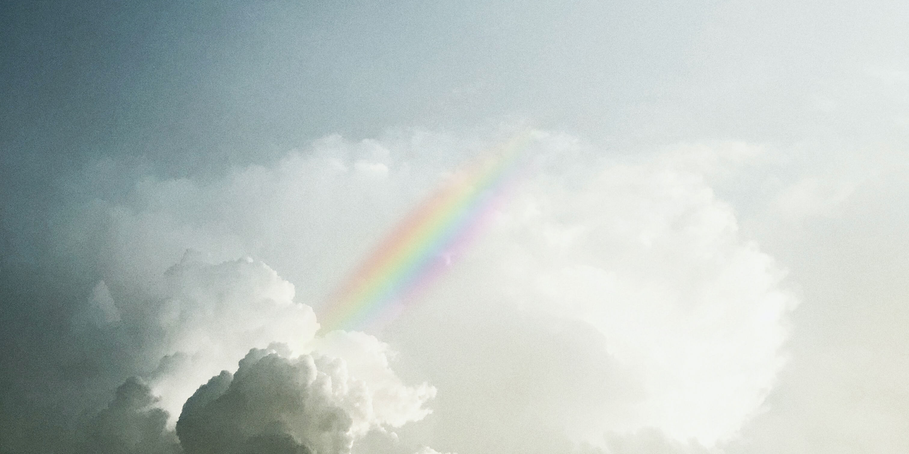 clouds in the sunlight with a rainbow