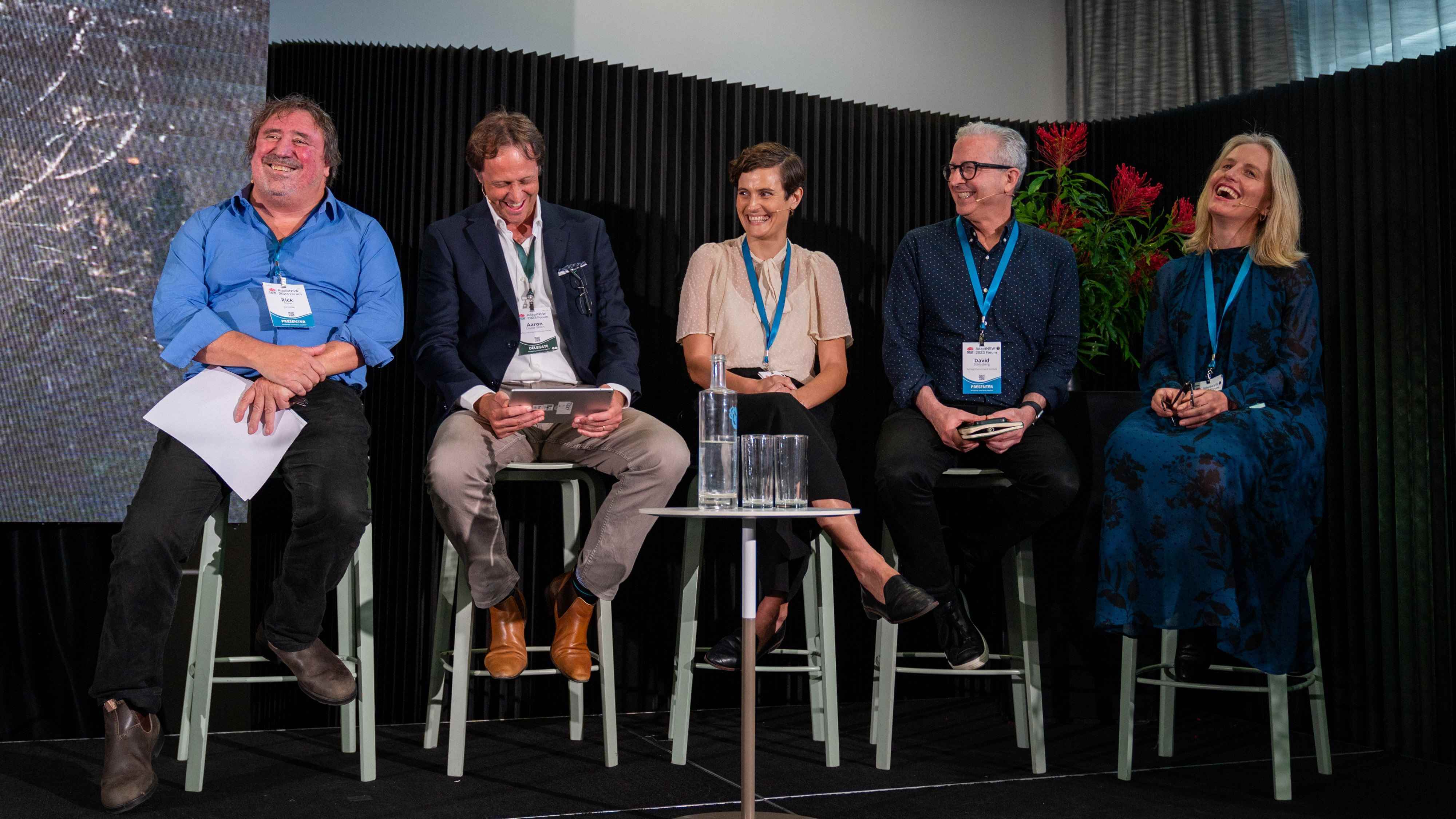 A group of five people seated in a row, part of a panel discussion at the 2023 AdaptNSW Forum.