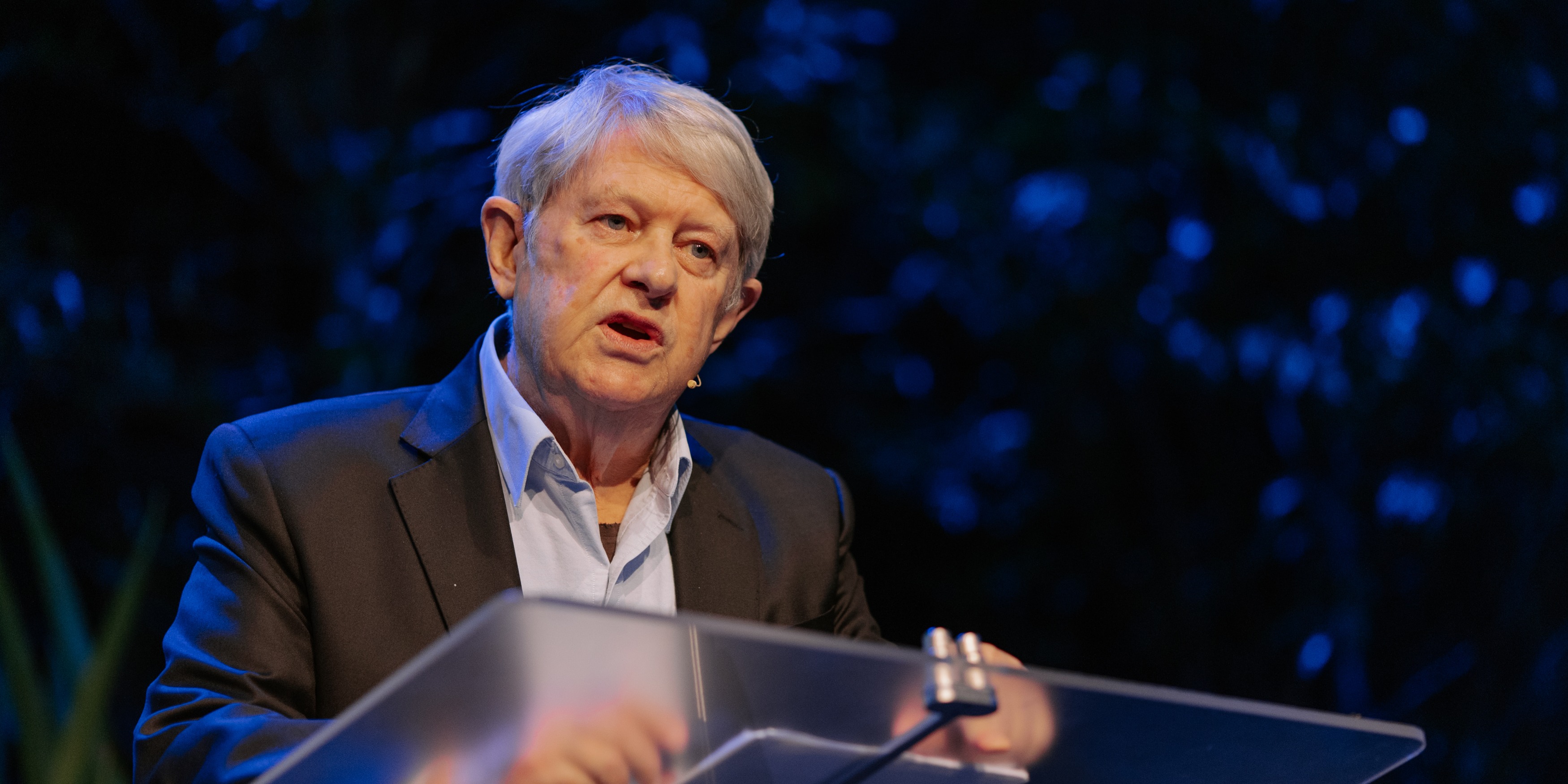 Bruce Chapman speaking at a lectern