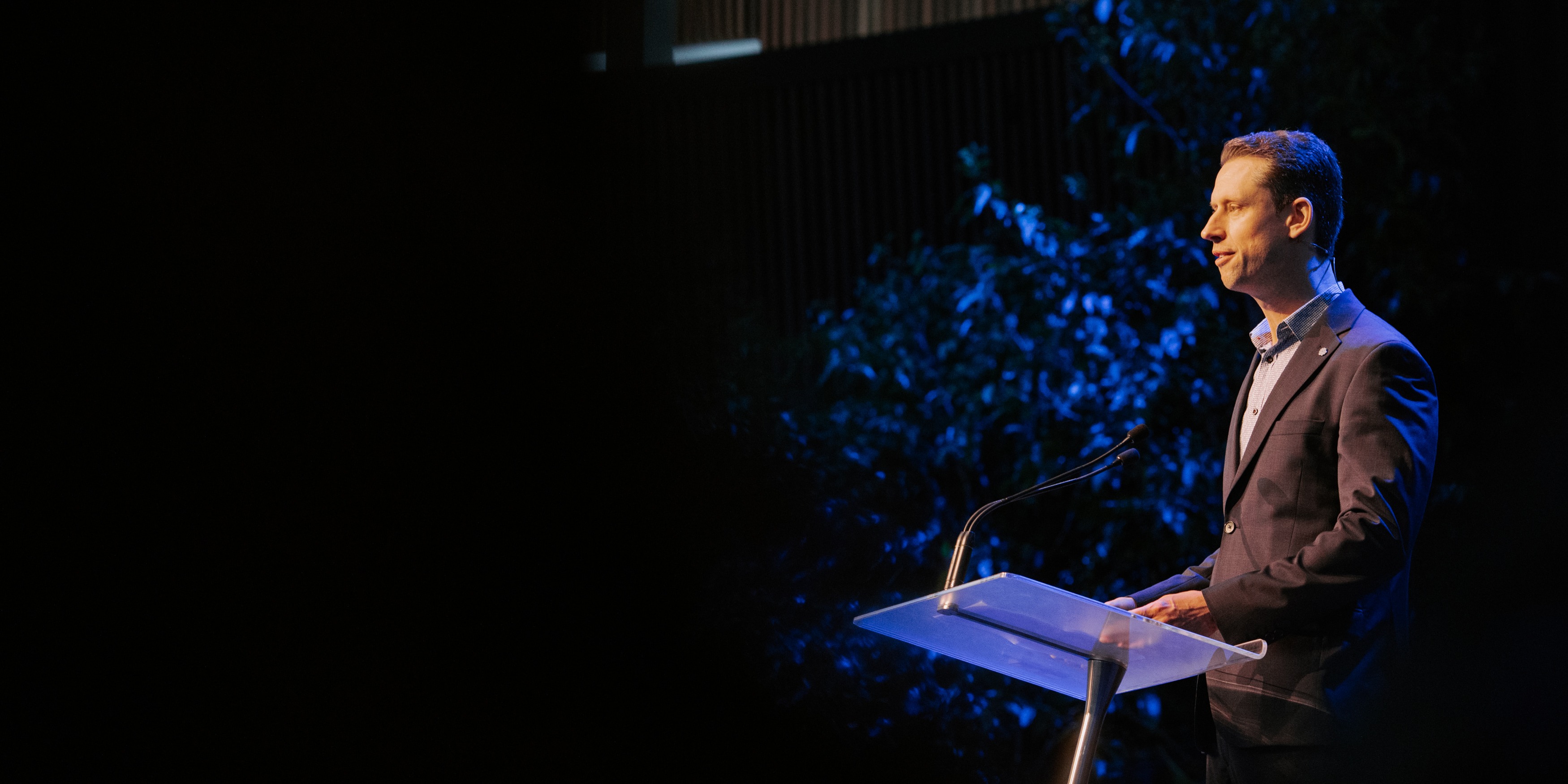 Male presenter standing behind lectern